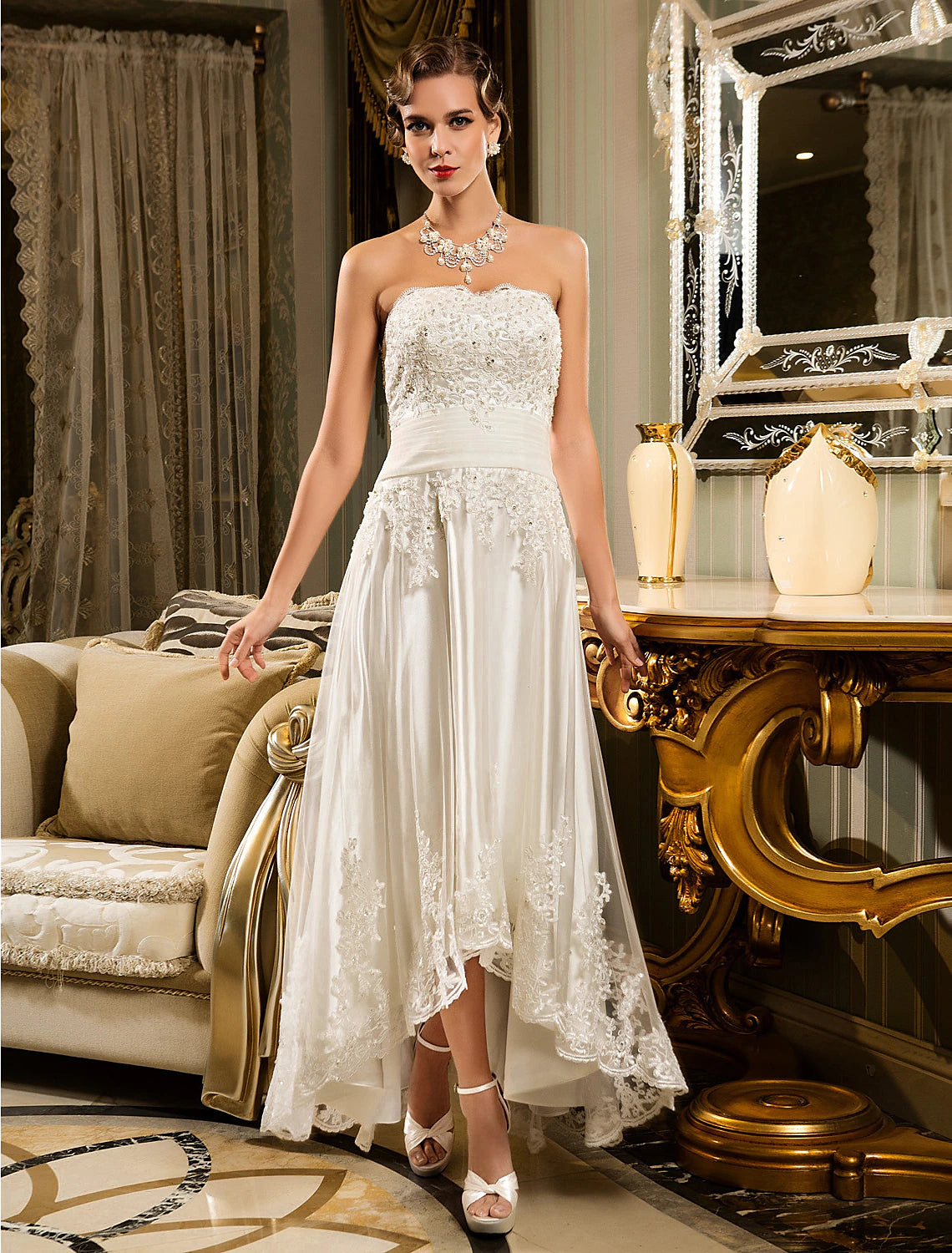 Model wearing an A-line sweetheart strapless little white reception dress with lace appliques.