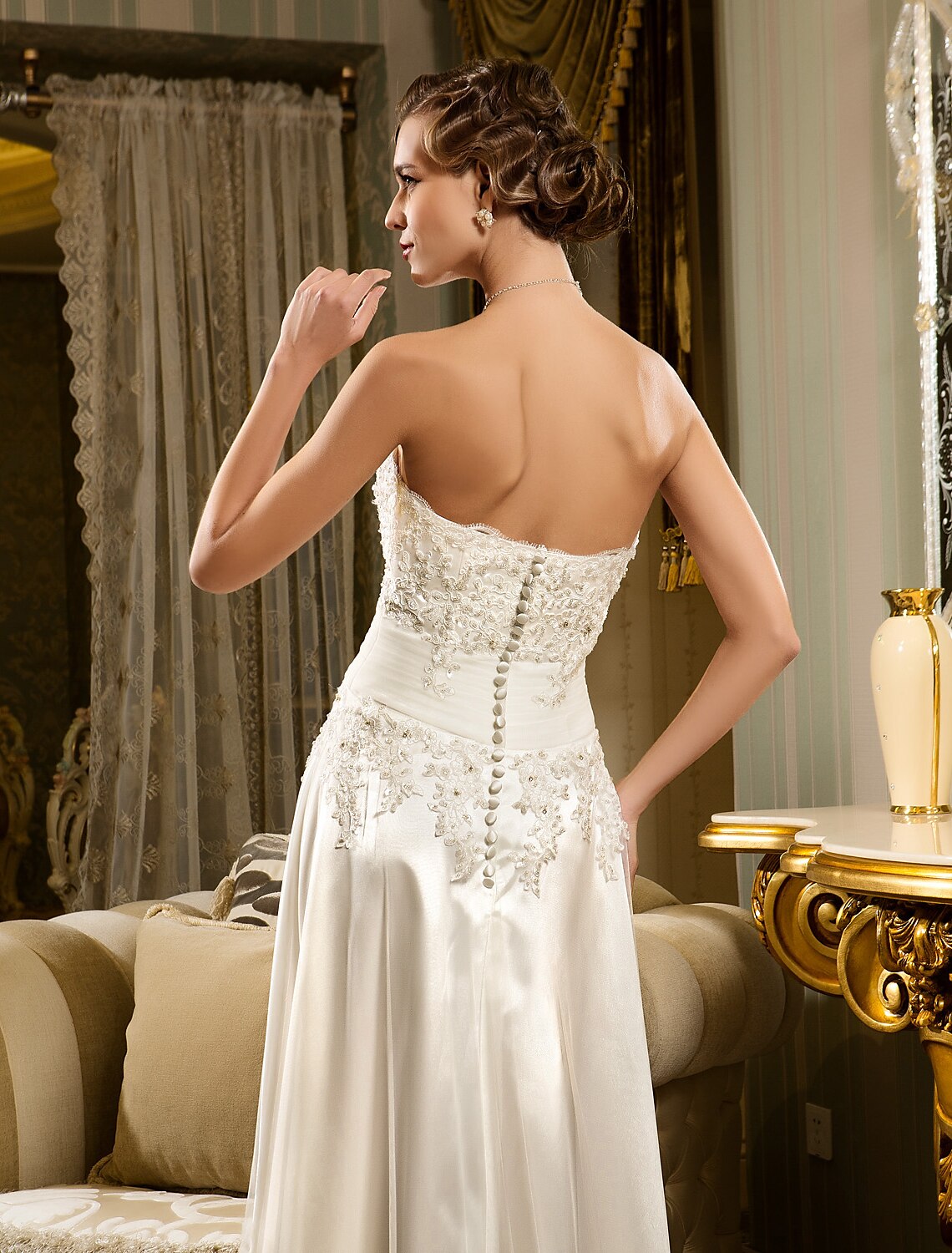 Back view of the A-line little white dress showing button details and asymmetrical hem.