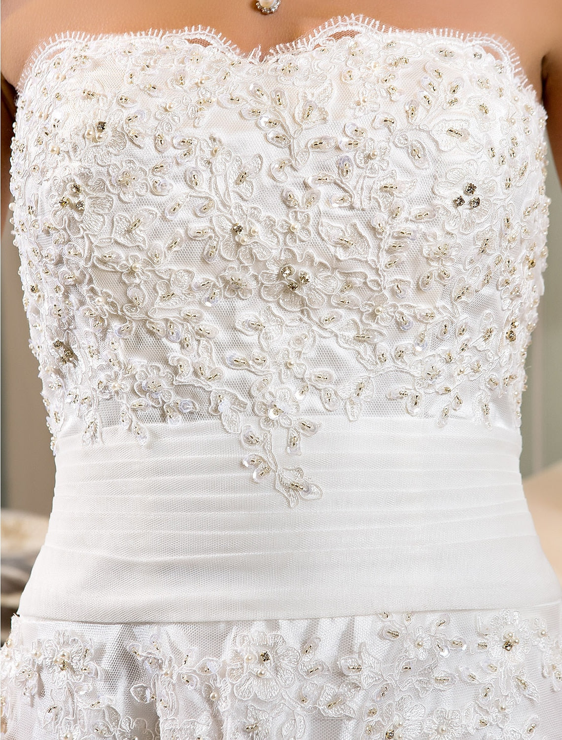 Rear view of the little white dress with button accents and train.