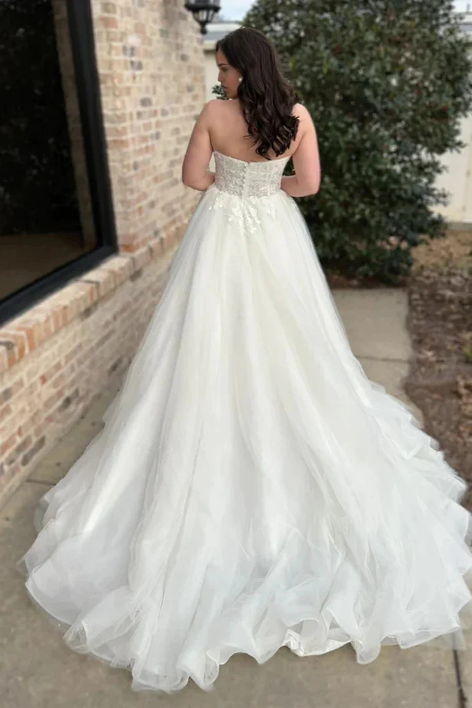 Full length view of a white lace strapless formal evening dress.