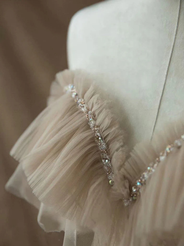 Woman posing in an elegant A-line sweetheart tulle lace long blush prom gown.