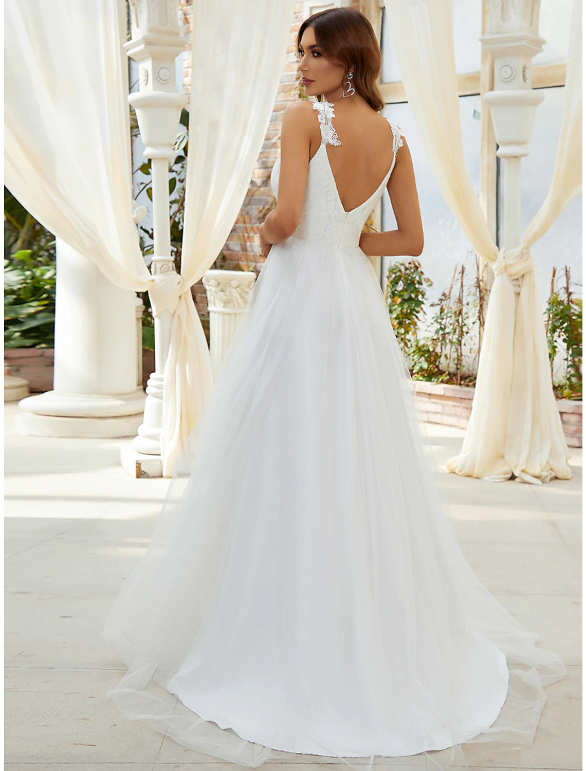 Close-up of sweetheart V-wire neckline and crystal appliques on tulle bridal gown.