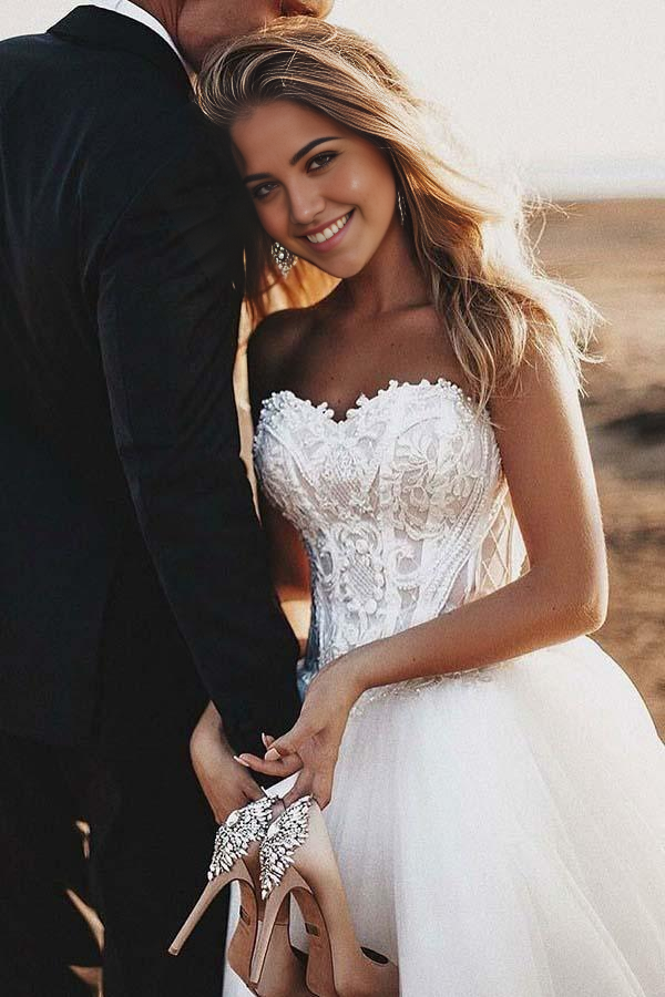 A-line sweetheart tulle wedding dress with intricate appliques and court train.