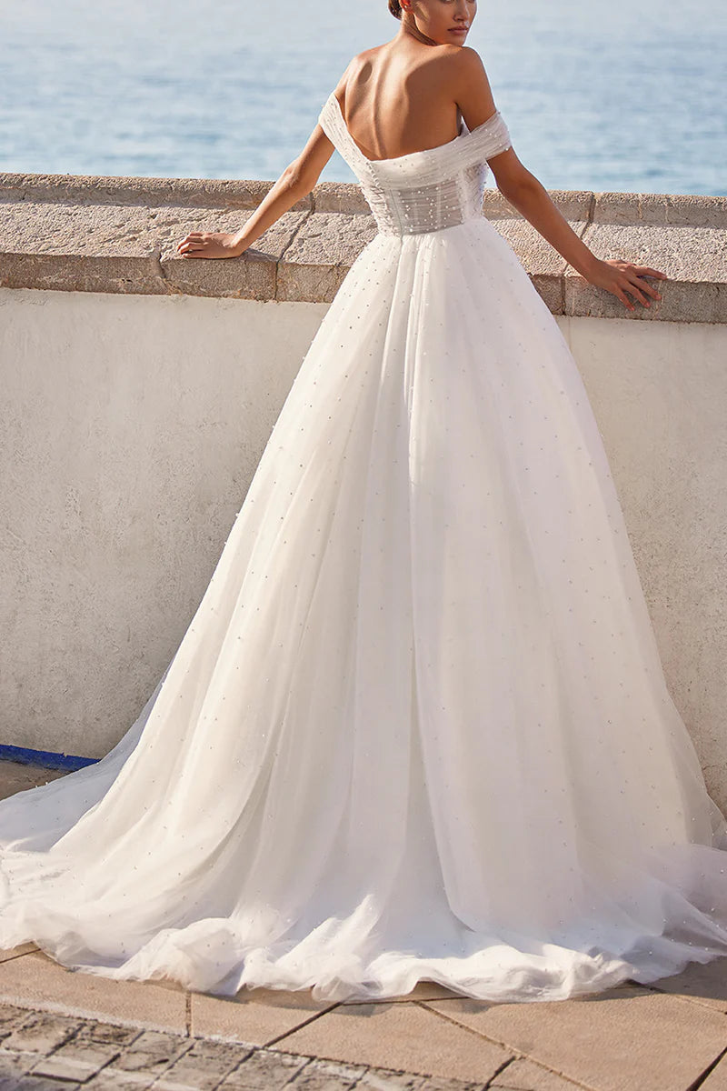 Side view of a sleeveless A-line wedding gown featuring a sweetheart neckline and delicate pearl details.