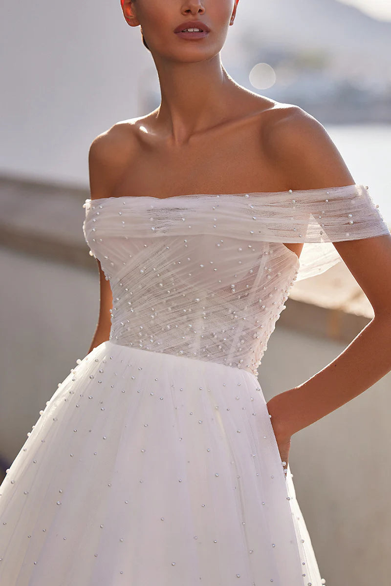 Close-up of the pearl embellishments on the tulle fabric of the A-line wedding dress.