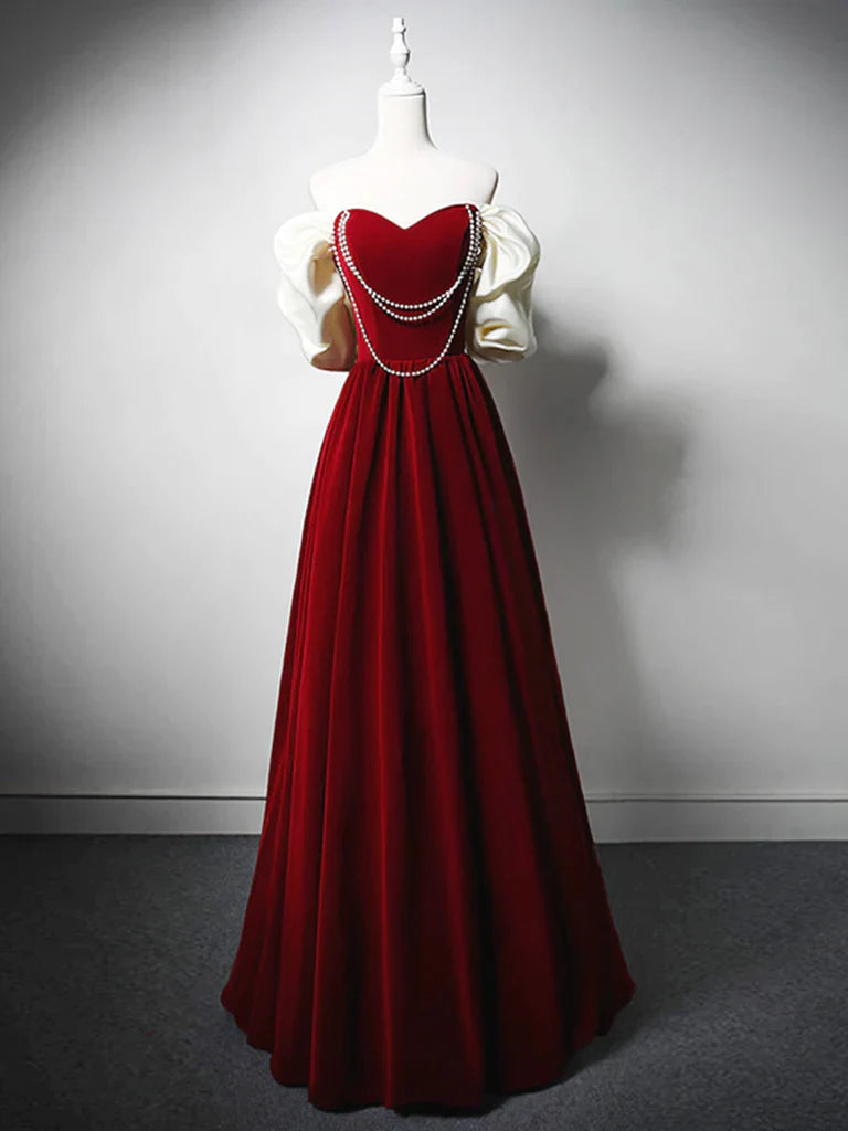 Woman wearing an elegant dark velvet A-line long prom dress with a sweetheart neckline.