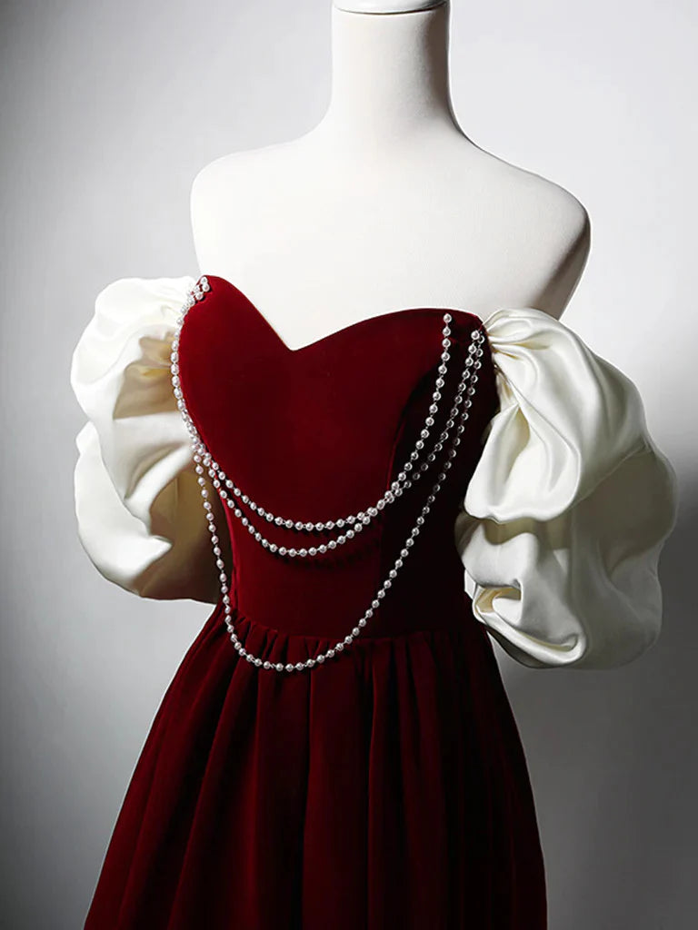 Side profile of a woman showcasing the flowing skirt of a dark velvet A-line dress.