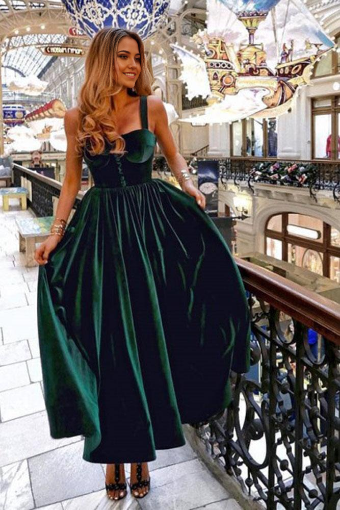 Model wearing a dark green velvet A-line prom dress with sweetheart neckline and open back.