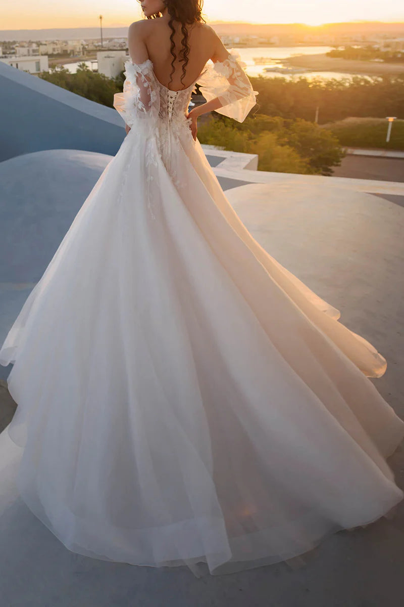 Side view of the A-line wedding dress, showcasing the flowing skirt and intricate 3D lace details on the long sleeves.