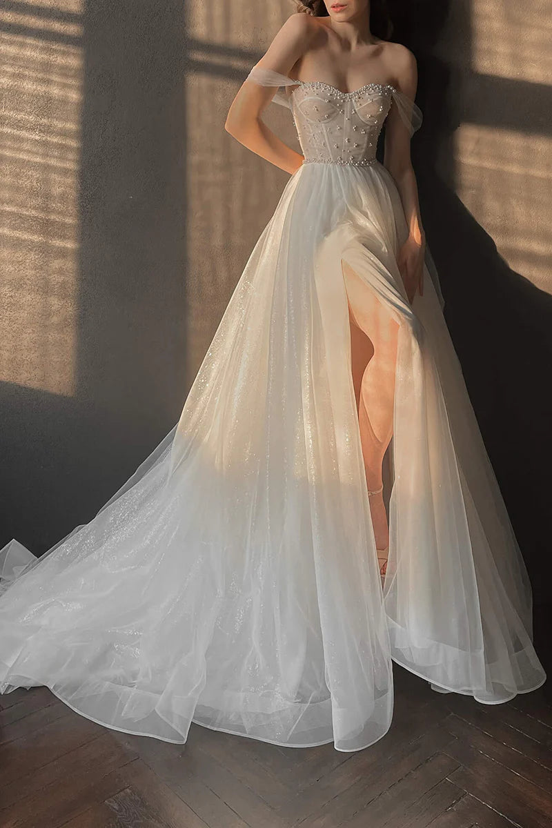 Bride wearing an elegant A-line wedding dress with a sweetheart neckline and pearl details.