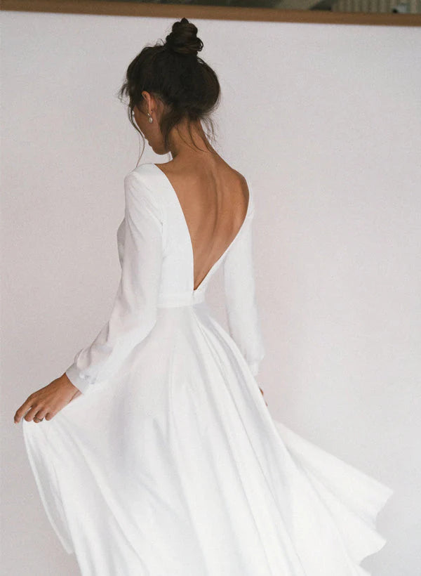 Back view of an elegant A-Line tea-length wedding dress with long sleeves.