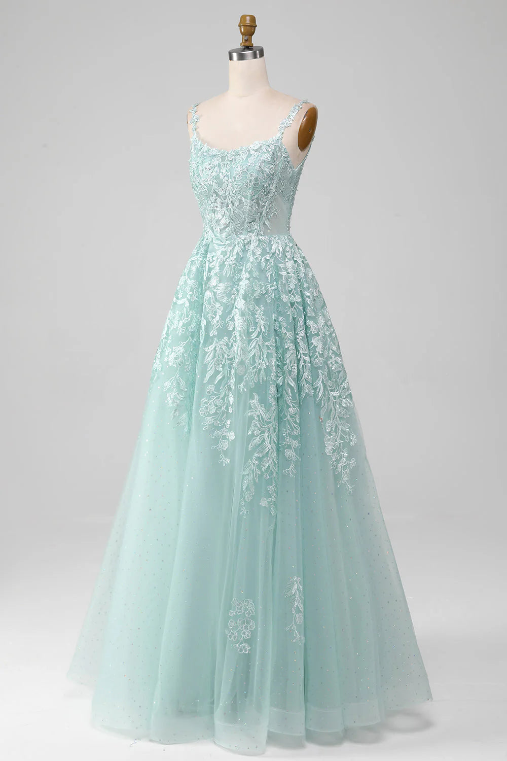 Side view of a model in a mint A-line tulle prom dress, showcasing the silhouette.