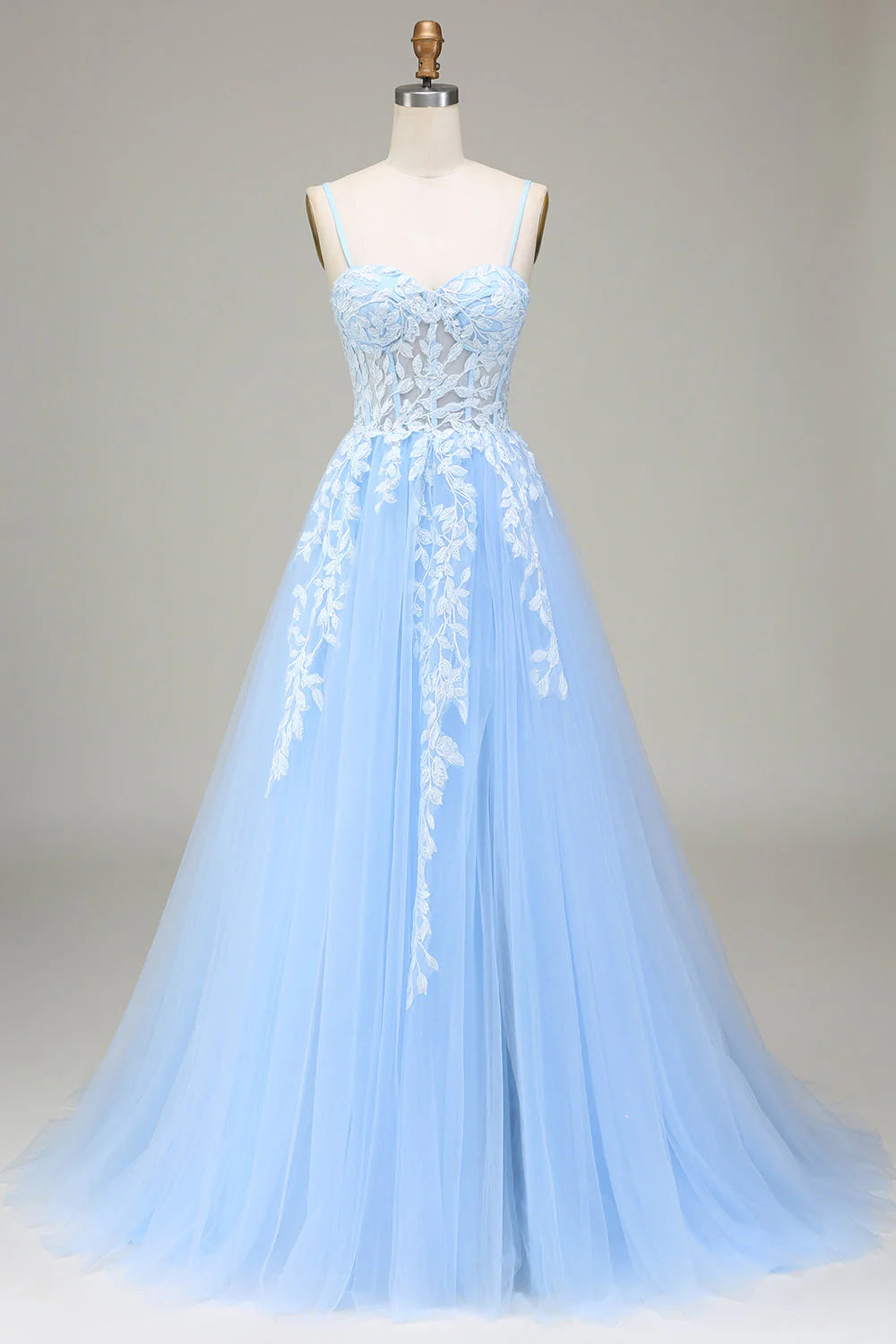 Model wearing an elegant A-Line tulle prom dress with spaghetti straps and appliques.