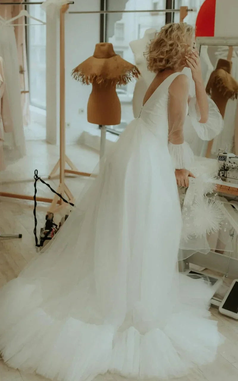 A-Line Tulle V-Neck wedding dress with delicate ruching, side view on model.