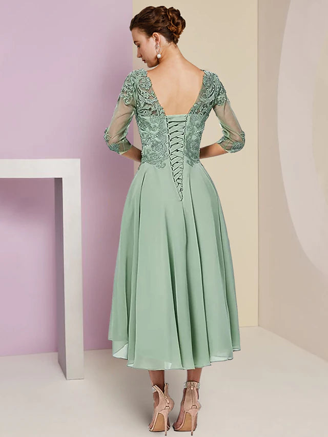 Side view of the slate blue two-piece dress, showing the half sleeves and asymmetrical tea length.