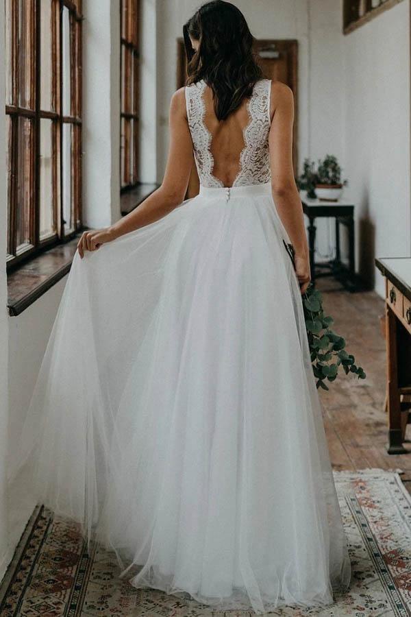 Full length view of a lace tulle bridal gown with V-back.