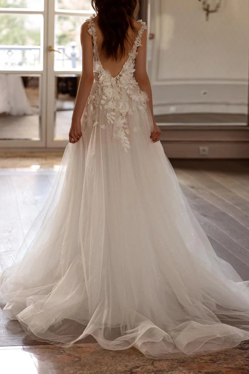 Back view of a flowing A-line wedding dress with intricate 3D floral appliques.