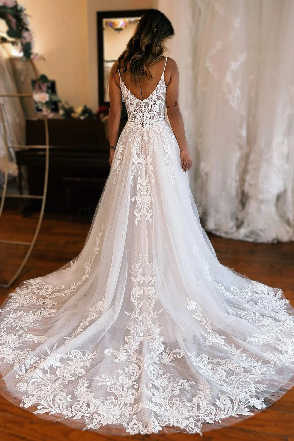 Back view of an A-line wedding dress with appliques and flowing skirt.