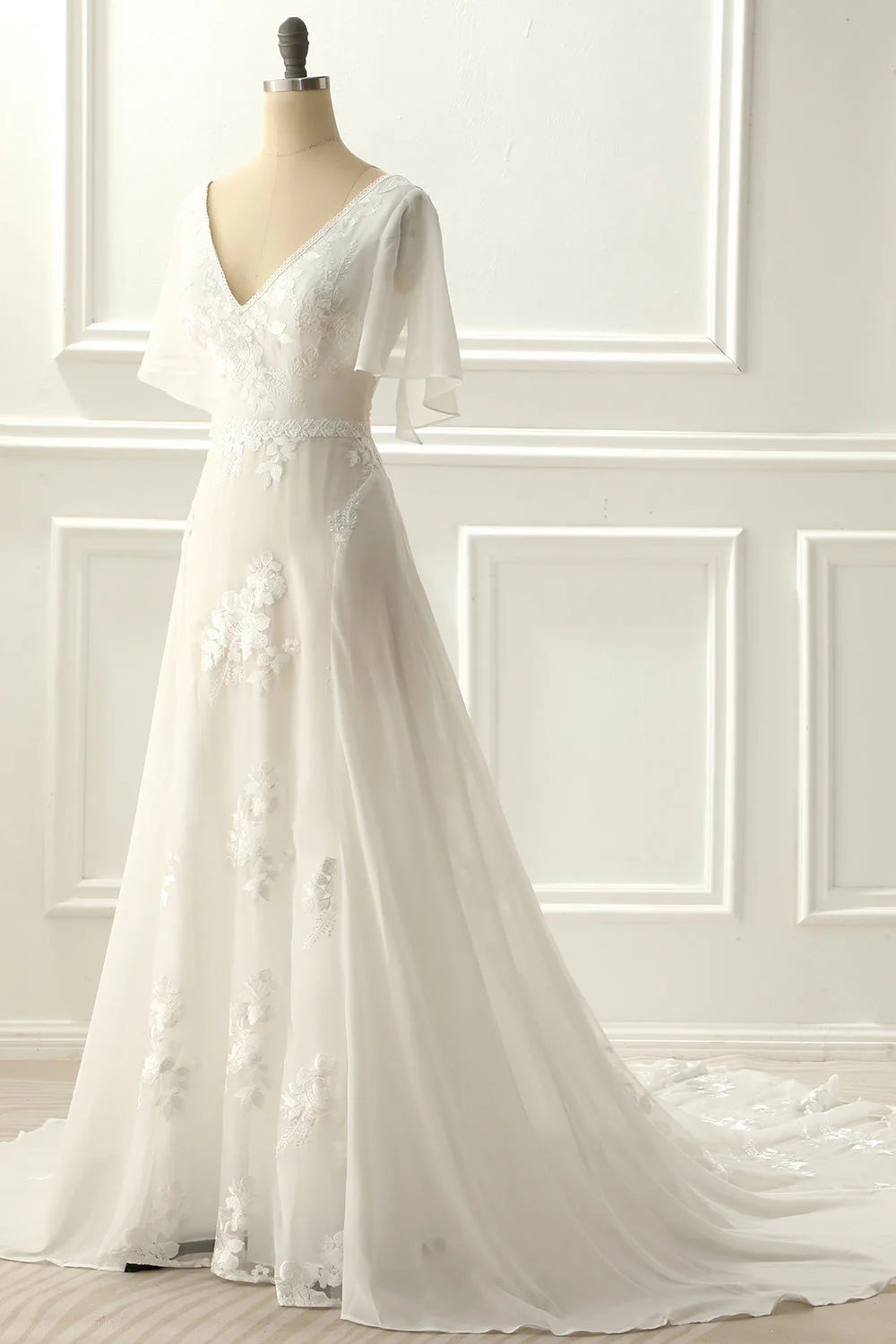 Close-up of intricate appliques on the V-neck A-line ivory wedding gown.