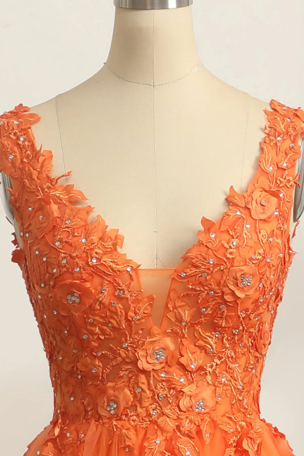 Applique embellishments on the V-neckline of the elegant prom dress.