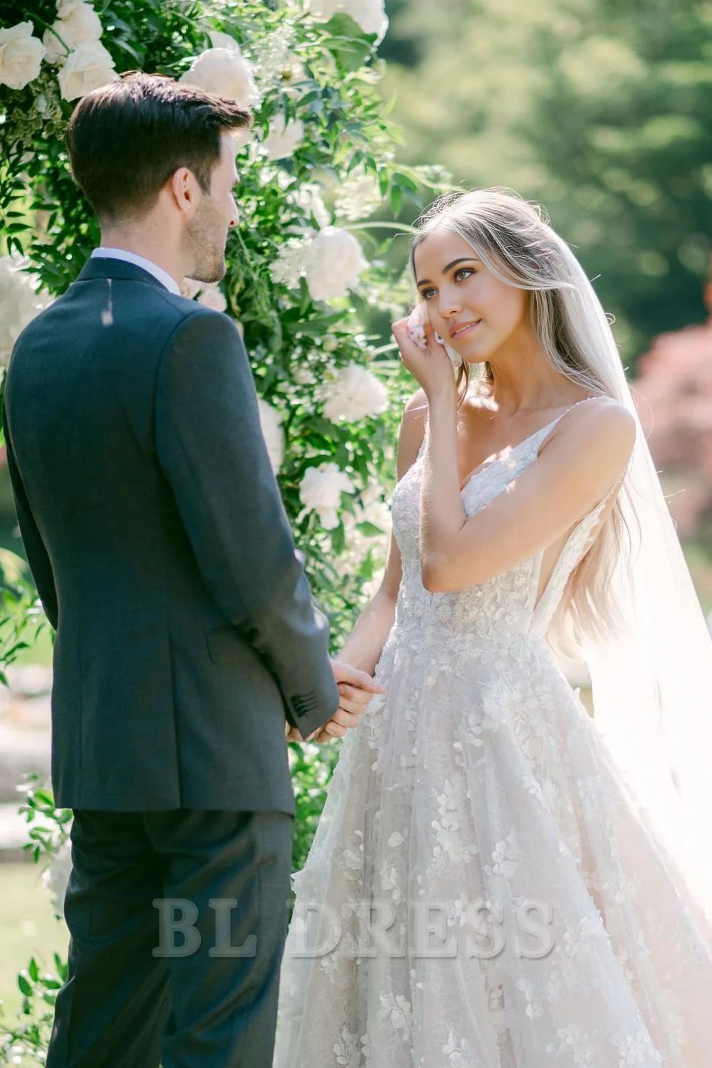 Side view of the long white bridal gown with delicate appliques.