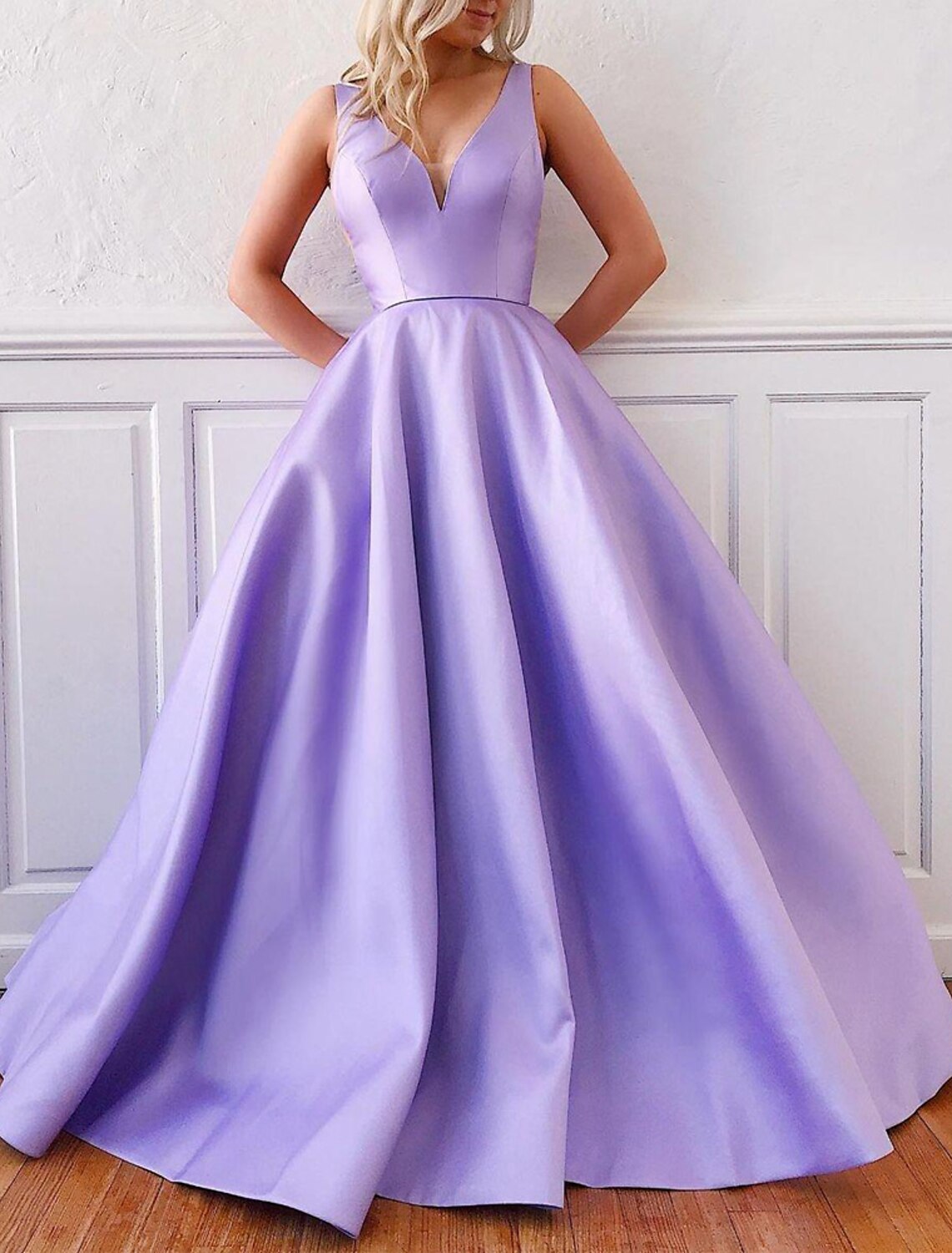 Back view of a sleeveless A-Line satin formal gown featuring a V-neck and elegant pleats.