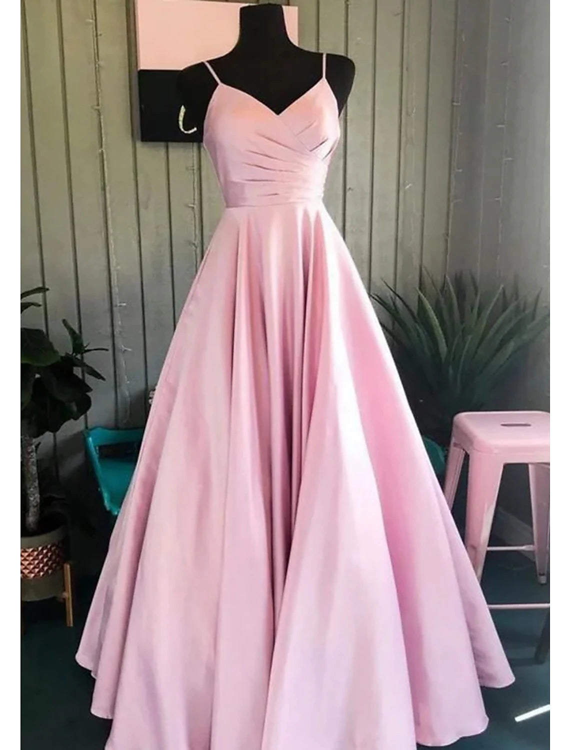 Model wearing an elegant A-line V-neck floor-length prom dress with ruched details.
