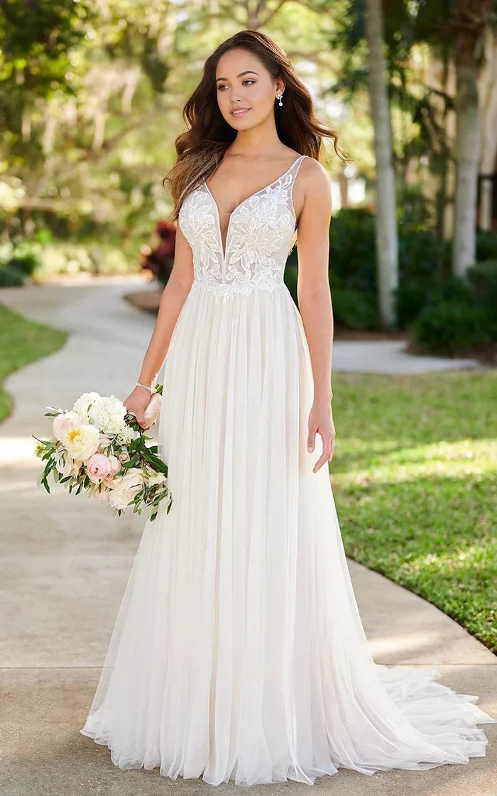Full view of an A-line tulle wedding dress with spaghetti straps and floral applique.