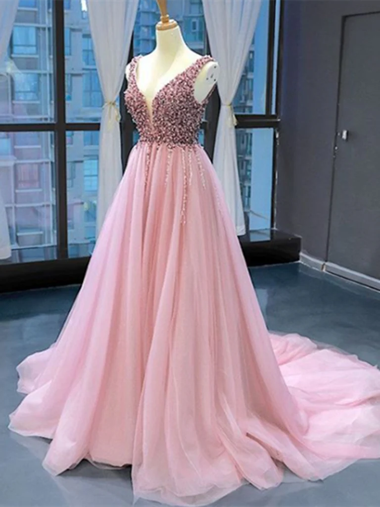 Woman wearing an elegant V-neck A-line tulle prom dress with intricate beading.
