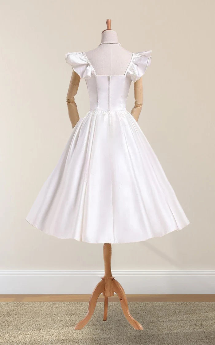 Close-up of the pleated satin fabric and bell sleeves on a white wedding dress.