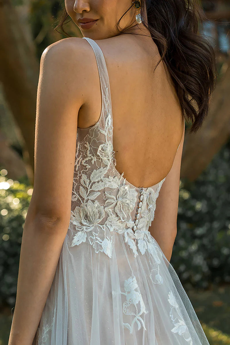 Close-up of delicate lace appliques on the V-neckline of the wedding dress.