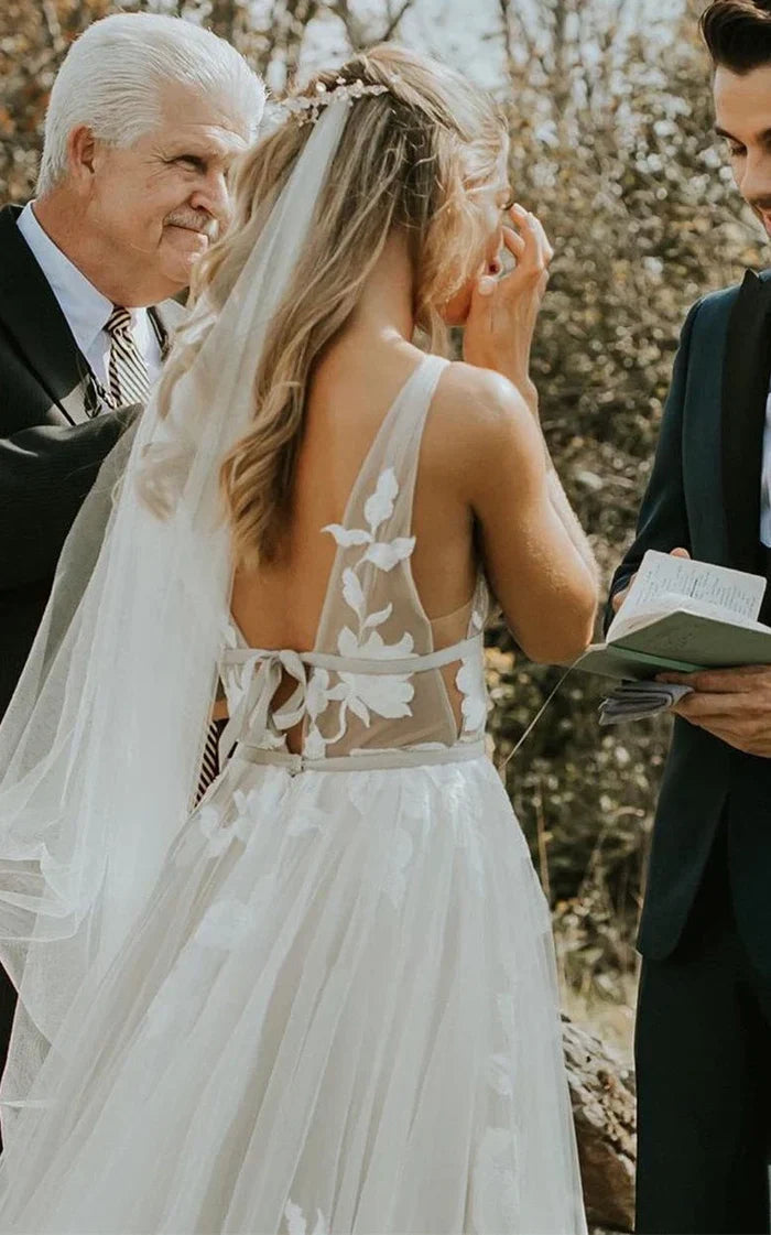 Full view of a sleeveless A-line wedding dress with lace and tulle.