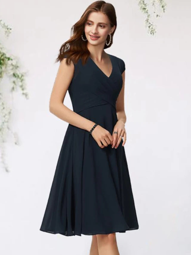 Elegant navy A-line Mother of the Bride dress with V-neck and cap sleeves on a model.