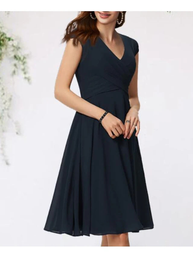 Close-up of the V-neckline and cap sleeve detail on the navy chiffon dress.