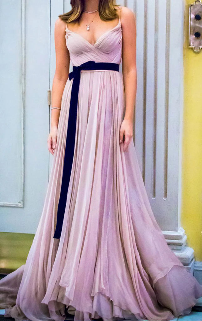 Woman wearing an elegant V-neck chiffon long prom dress with spaghetti straps.