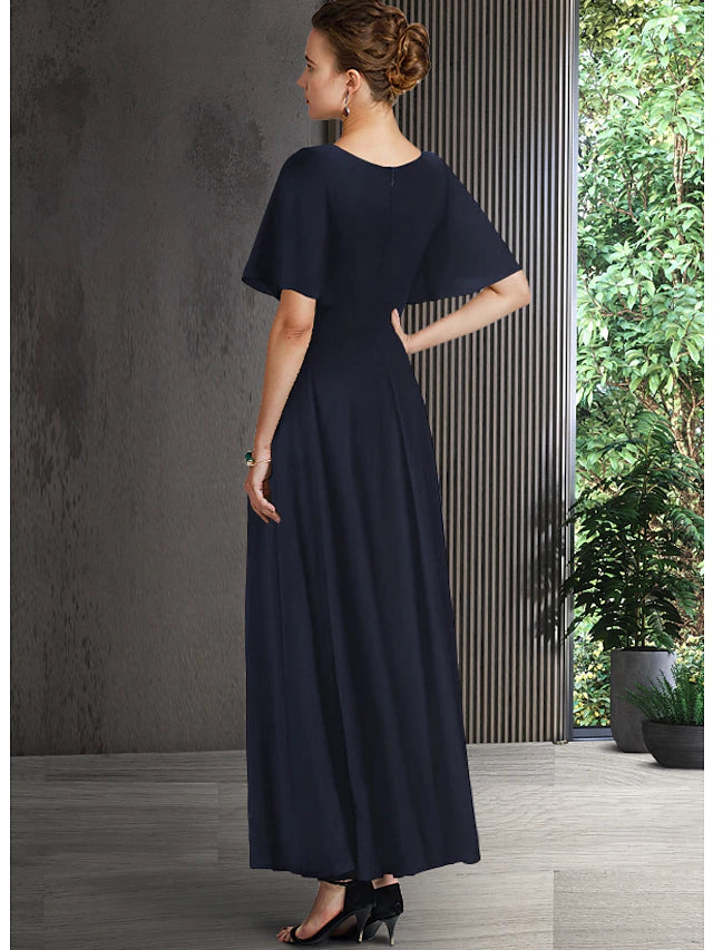 Full view of the A-line chiffon dress with pleats and crystal brooch detail.