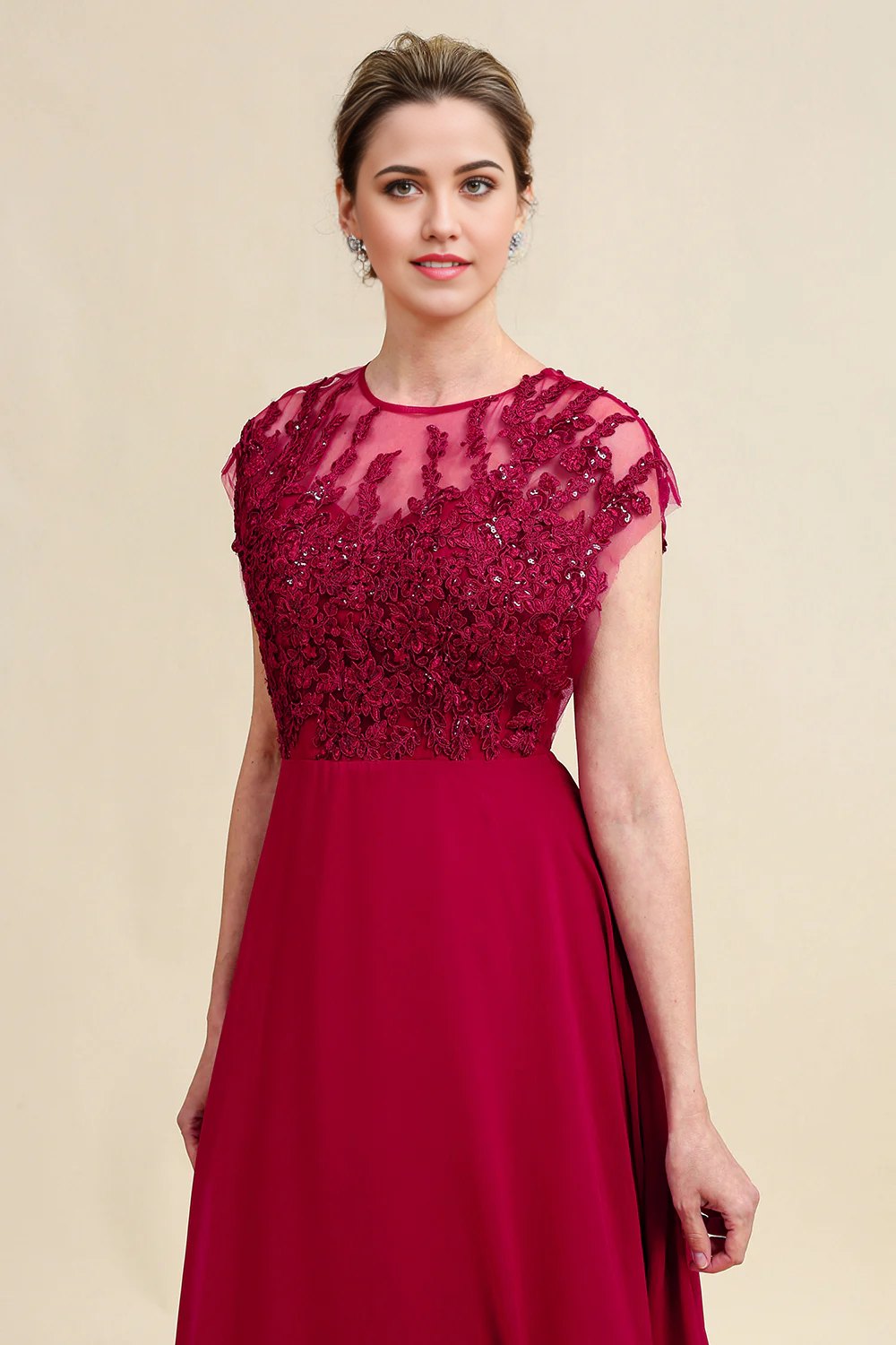 Back view of a woman wearing a flowing A-line chiffon gown with lace accents.