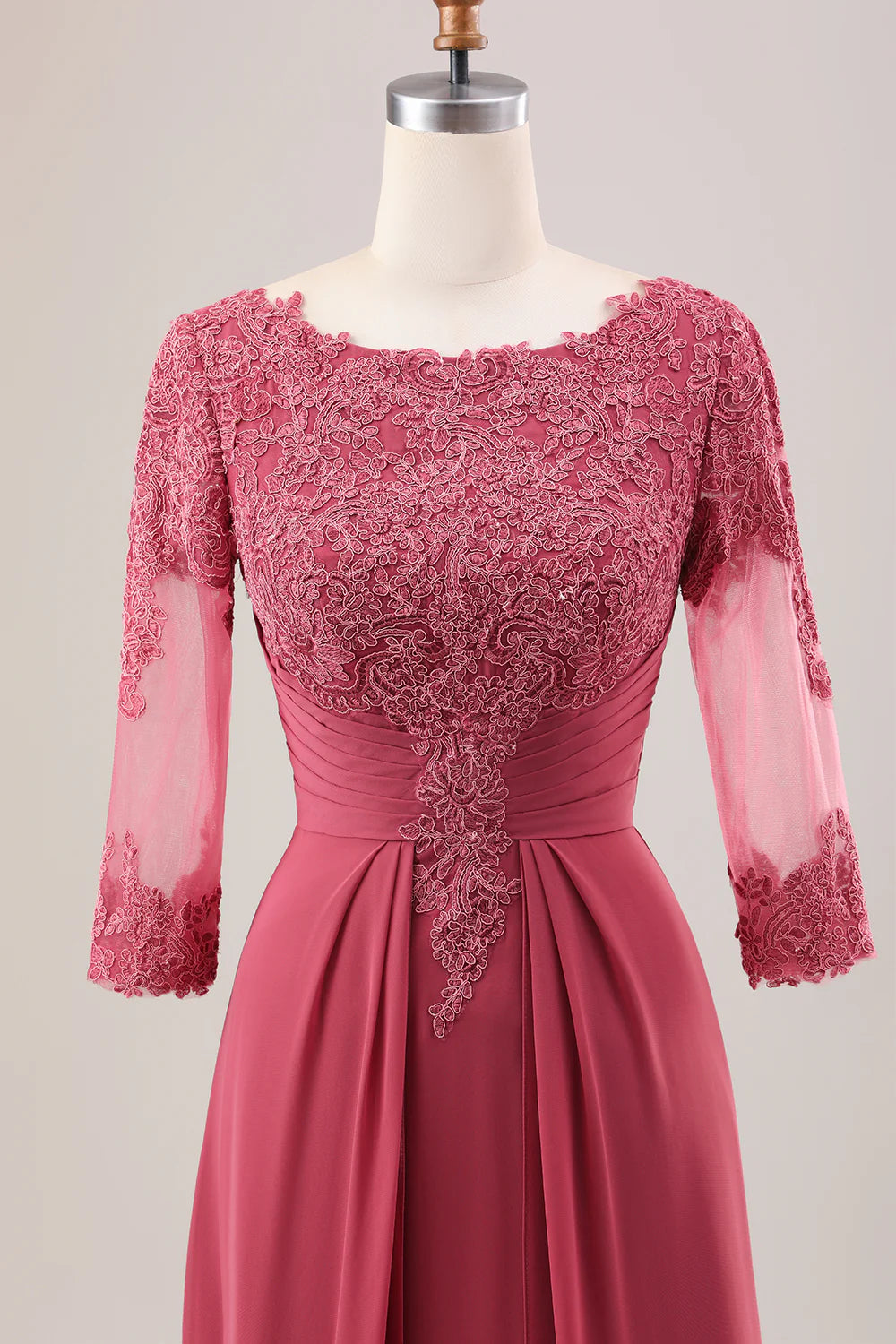 Detailed view of the delicate appliques on the terracotta chiffon fabric of the dress.