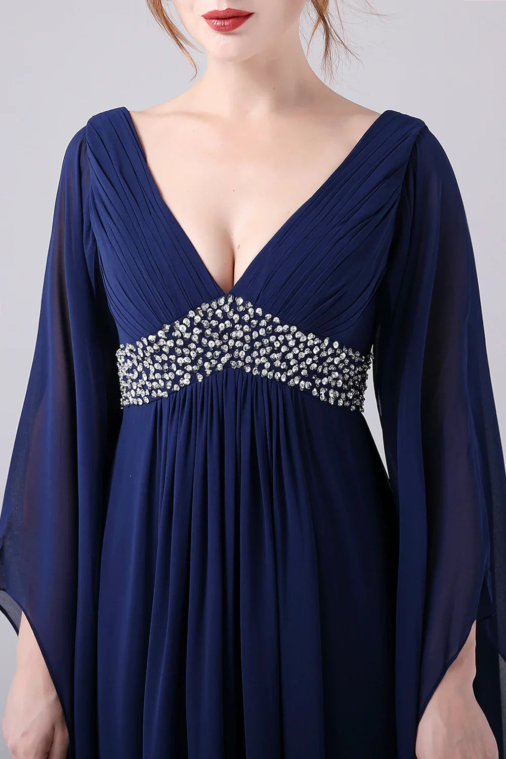 Full length view of a woman wearing an A-line V-neck chiffon dress.