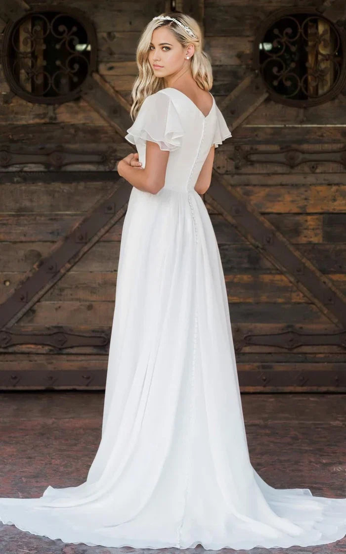 Back view of A-line wedding dress showing floor-length train and ruffles.