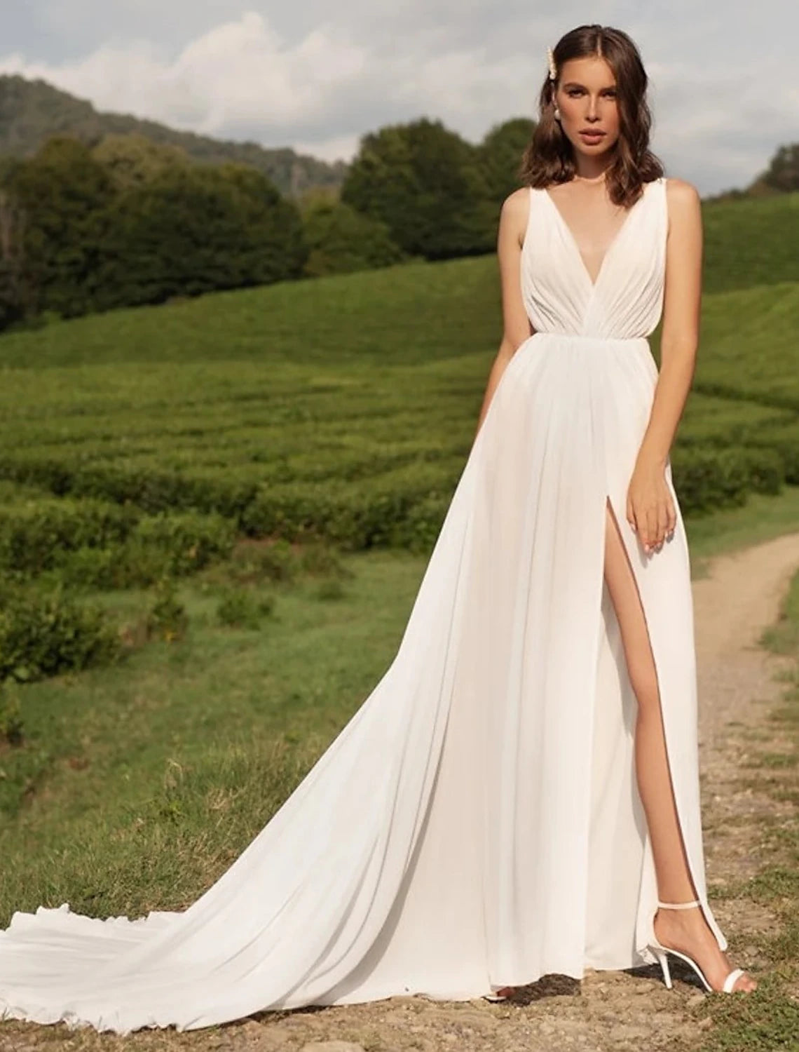 Model wearing an elegant white A-line V-neck chiffon wedding dress with a split front and court train.