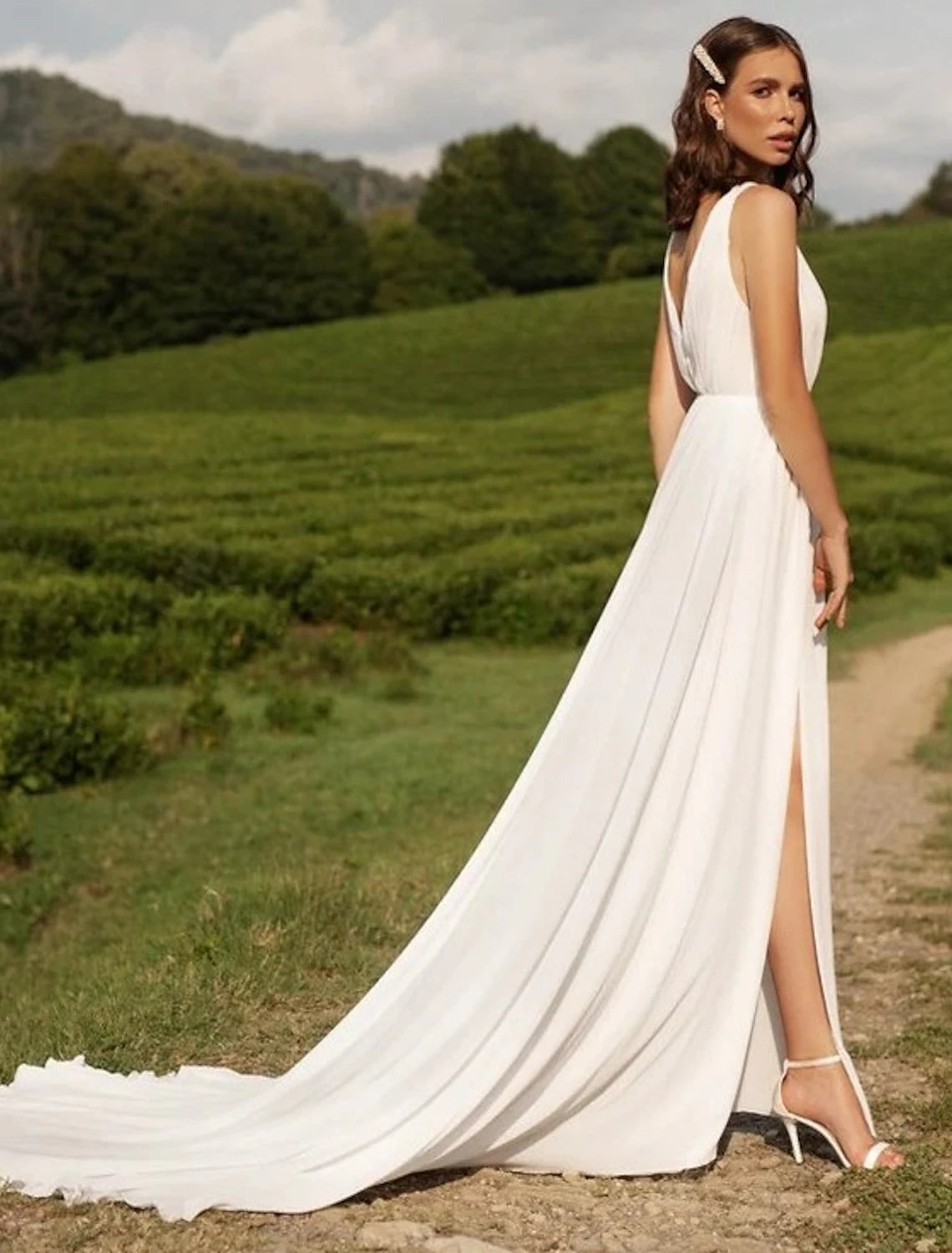 Side view of a white A-line V-neck chiffon wedding dress, showing the split front detail.