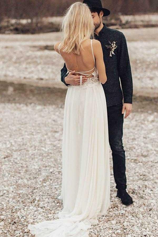 Back view of a long chiffon wedding dress with delicate lace details.