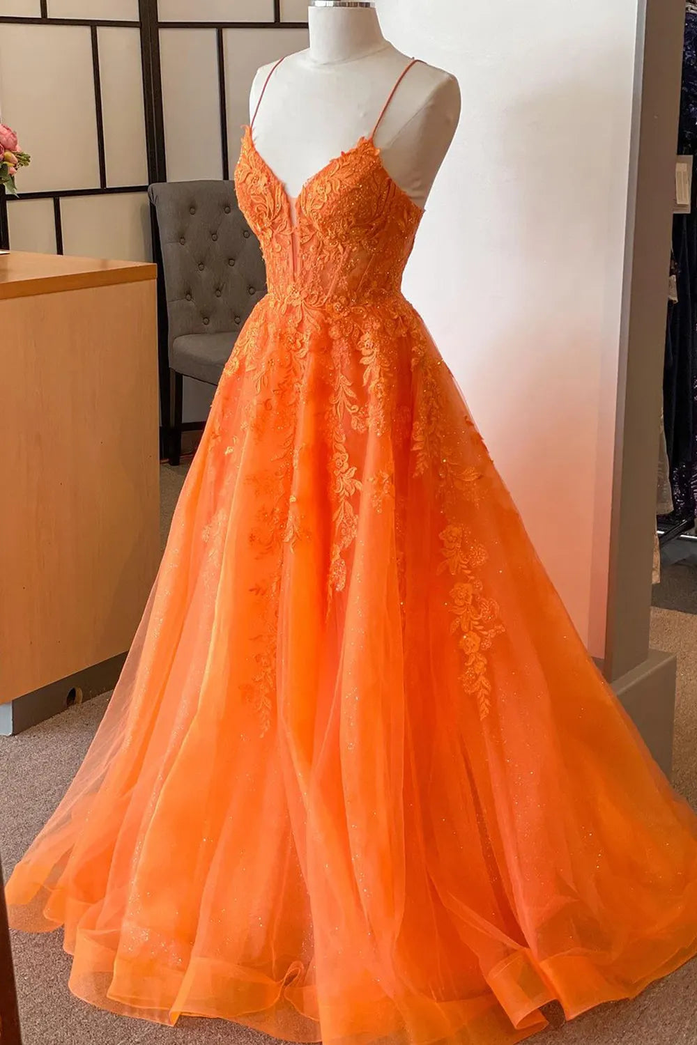 Close-up of appliques and corset on a V-neck prom dress.