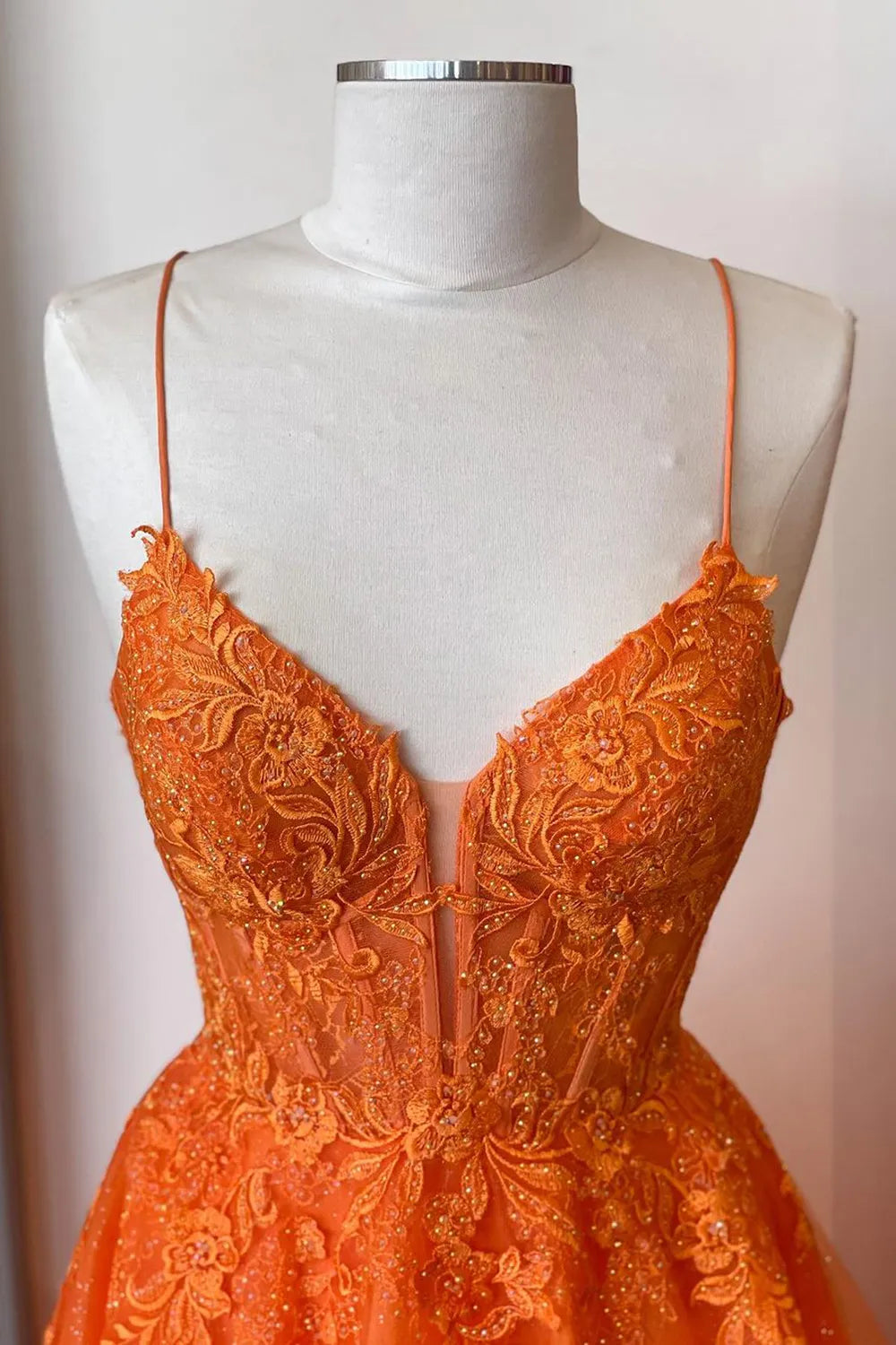 Side view of a long A-line prom dress with spaghetti straps.