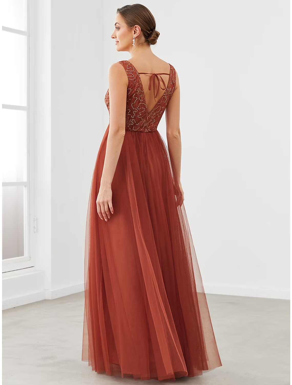 Close-up of V-neckline and draped tulle fabric on formal dress.