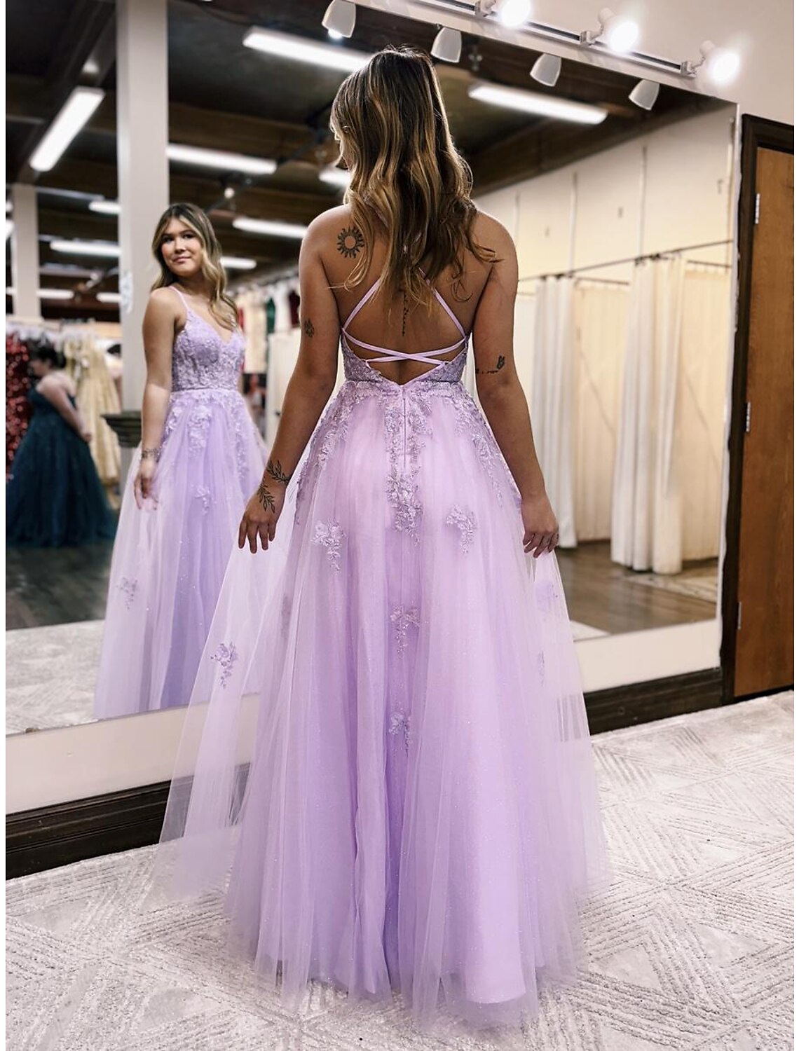 Back view of the A-line evening gown, highlighting the open back and delicate beading.
