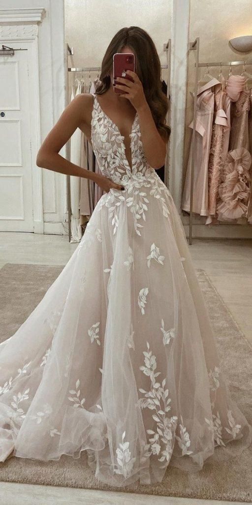 Model wearing an elegant A-line V-neck floor-length lace wedding dress, front view.