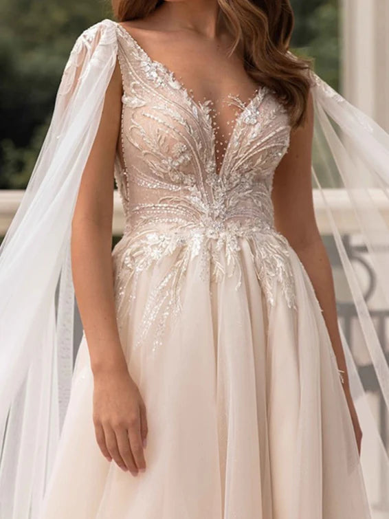 Detailed view of the V-neckline and flowing skirt of the bridal dress.