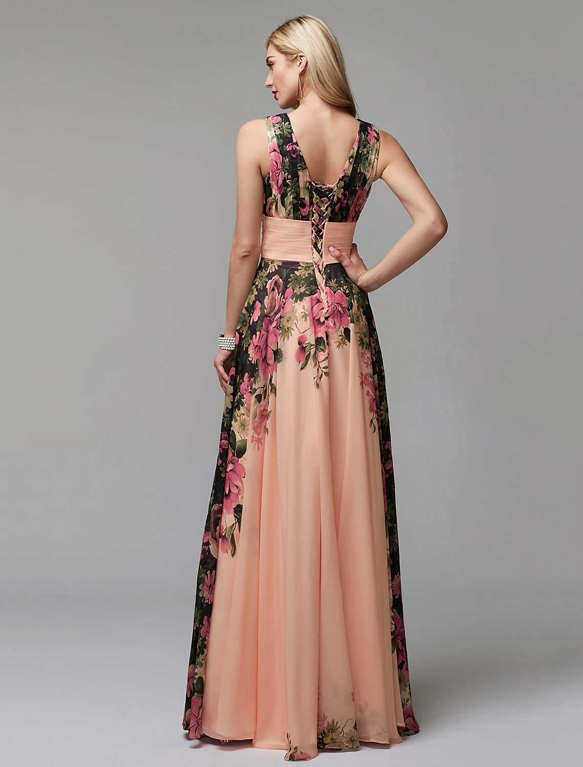 Side view of a woman in an A-line floral chiffon V-neck floor-length dress.